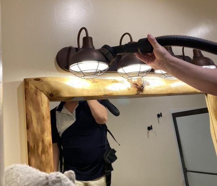 vacuuming lite fixtures over a mirror 